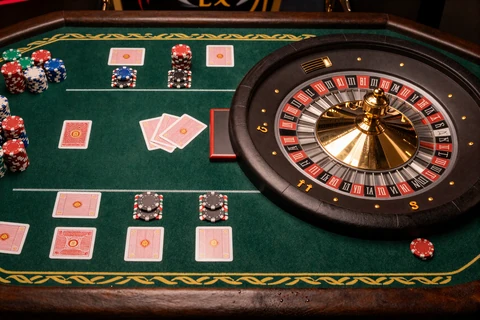 Roulette und Blackjack Tische nebeneinander mit goldenen Chips und r&ouml;mischem Lorbeerrand